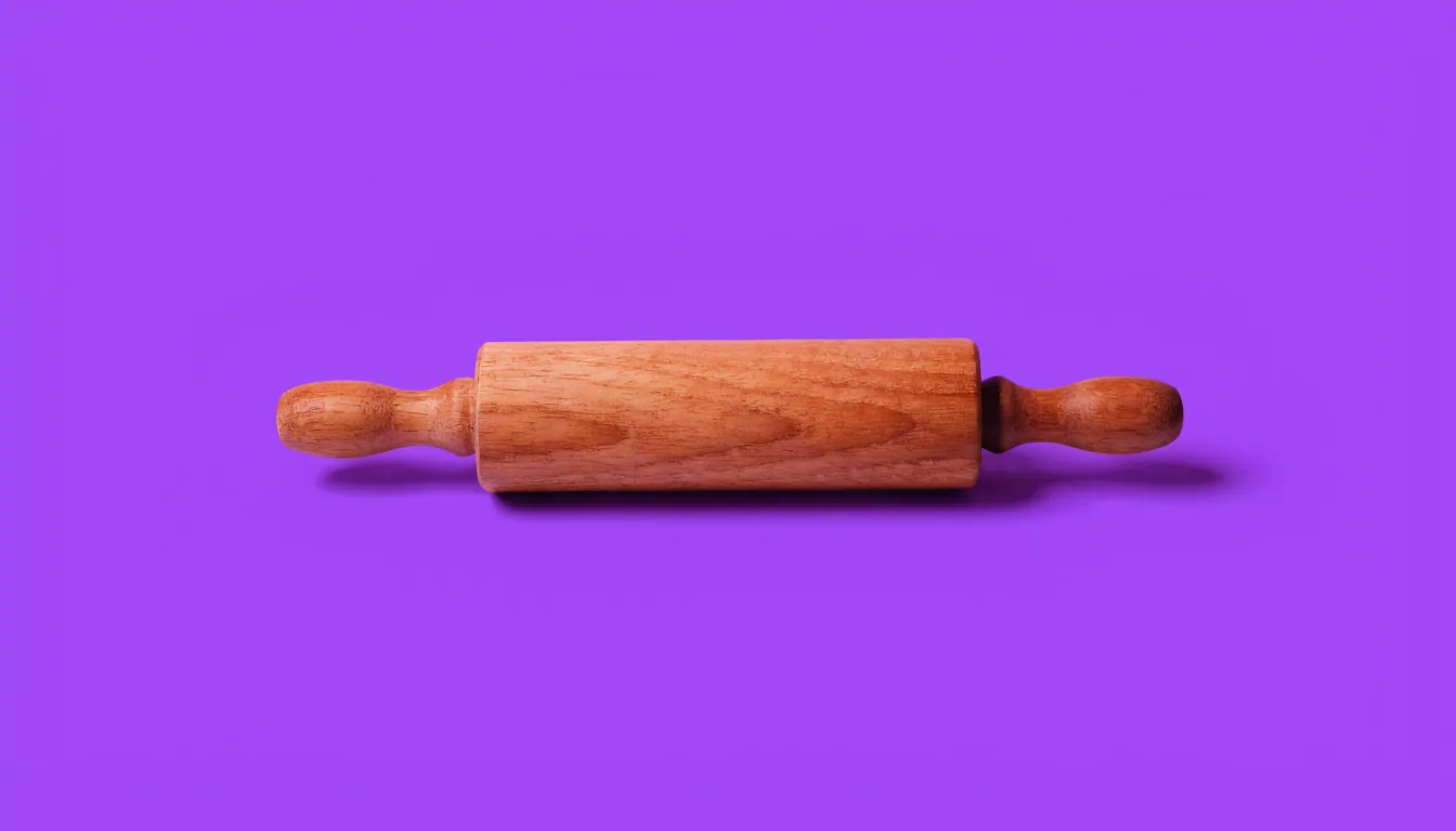 A single wooden rolling pin centred on a solid purple background, photographed in soft studio light.